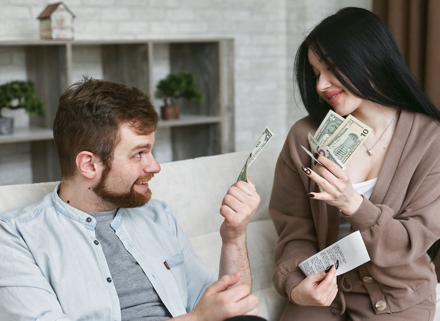 Casal comemorando dinheiro extra em casa